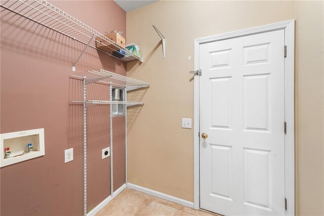 clothes washing area featuring light tile patterned floors, hookup for a washing machine, and electric dryer hookup