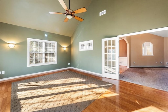 spare room featuring hardwood / wood-style flooring, ceiling fan, and high vaulted ceiling