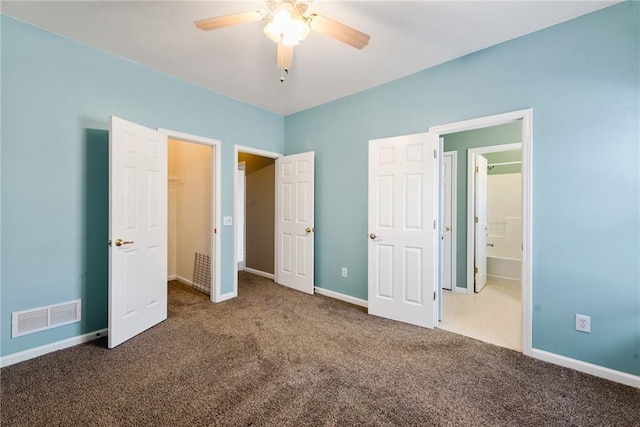 unfurnished bedroom with connected bathroom, ceiling fan, and dark colored carpet