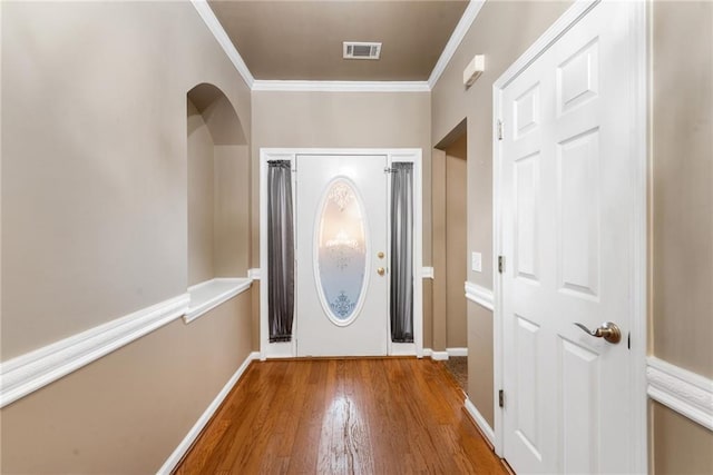 entrance foyer with crown molding and hardwood / wood-style floors