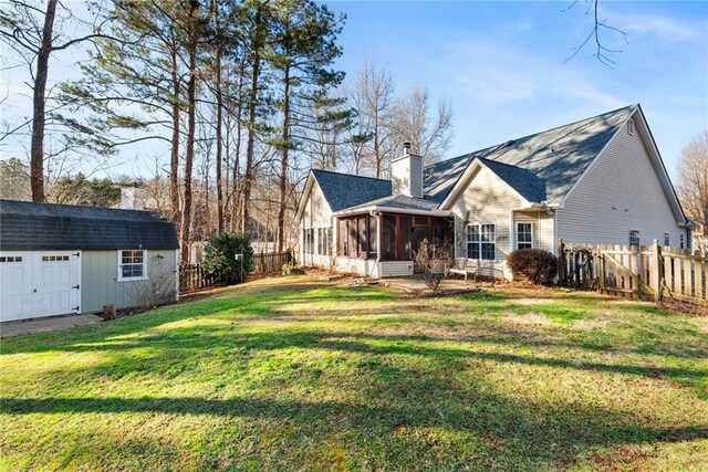 exterior space with a shed, a lawn, and a sunroom