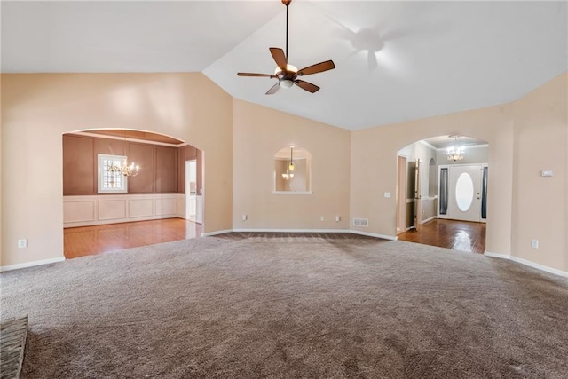 unfurnished living room with vaulted ceiling, carpet flooring, and ceiling fan with notable chandelier