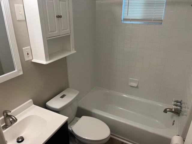 full bath featuring toilet, washtub / shower combination, and vanity