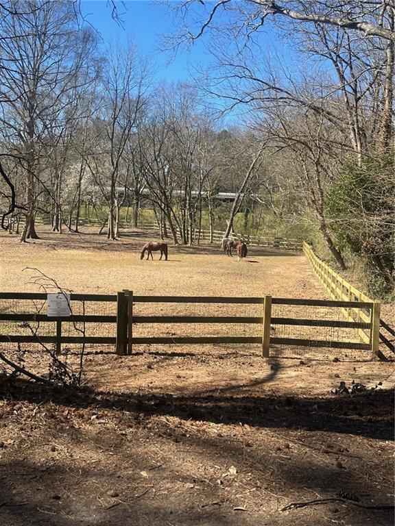 view of property's community featuring a rural view and fence