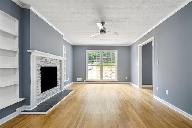 unfurnished living room with a fireplace, light wood-type flooring, ornamental molding, a textured ceiling, and ceiling fan