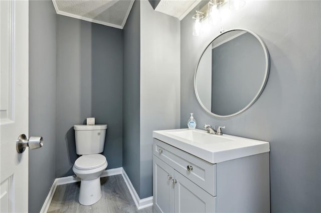 bathroom featuring crown molding, vanity, toilet, and wood-type flooring