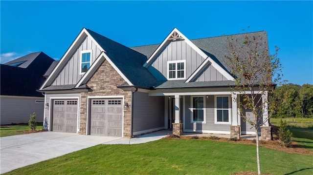 craftsman-style home featuring a front lawn, covered porch, and a garage