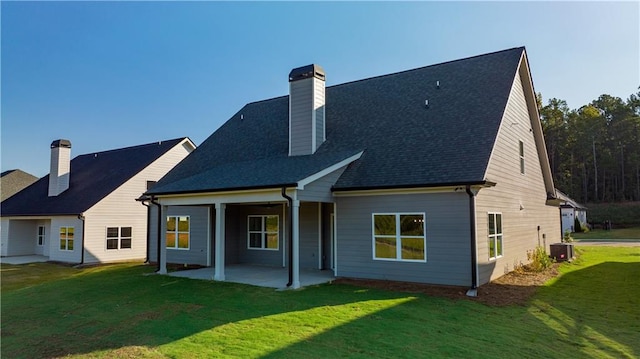 back of house featuring central air condition unit, a patio area, and a lawn