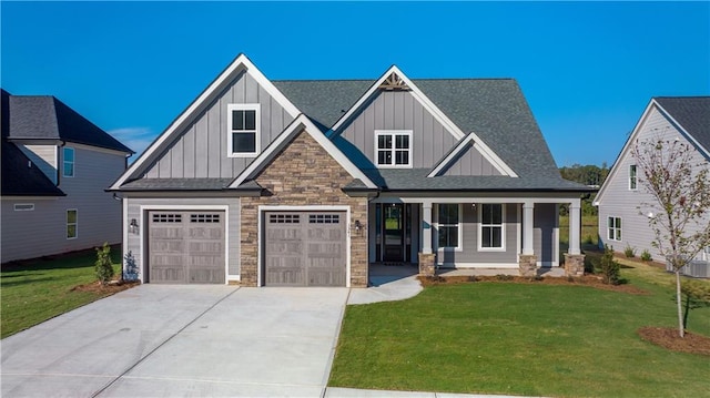 craftsman house with a garage, covered porch, and a front lawn