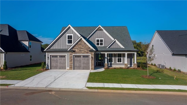 craftsman-style home with a garage, central air condition unit, and a front yard