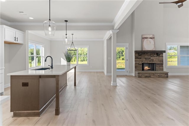 kitchen with sink, plenty of natural light, decorative light fixtures, a center island with sink, and white cabinets