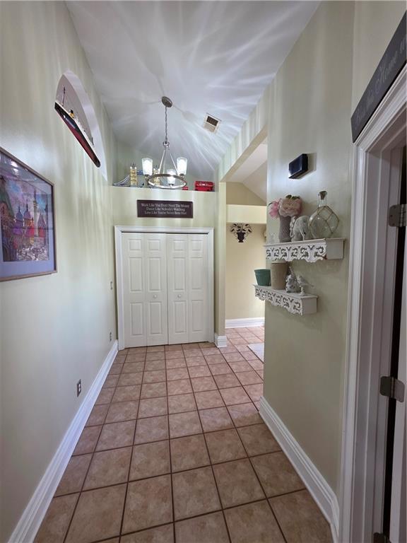 interior space with an inviting chandelier, visible vents, and lofted ceiling