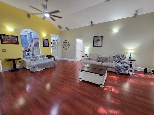 living area featuring ceiling fan, visible vents, vaulted ceiling, arched walkways, and wood finished floors