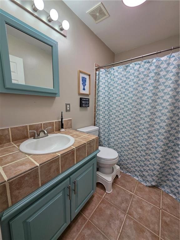 bathroom featuring vanity, visible vents, toilet, and tile patterned flooring