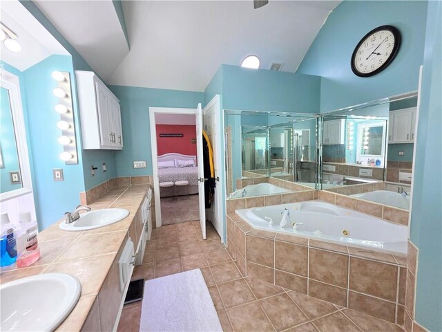 full bathroom with a tub with jets, ensuite bath, a shower stall, a sink, and lofted ceiling