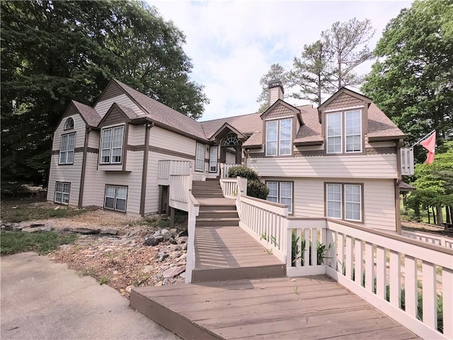 view of front of house with roof with shingles and a chimney