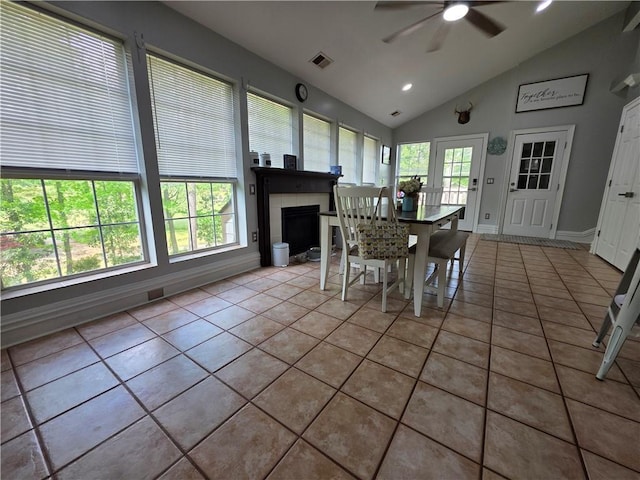 tiled dining space with lofted ceiling, visible vents, recessed lighting, a fireplace, and a ceiling fan