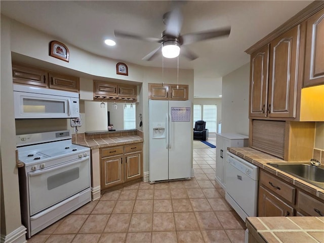kitchen featuring a sink, ceiling fan, tile countertops, and white appliances