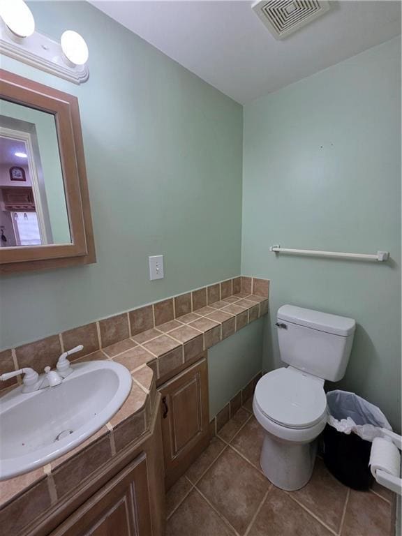 bathroom featuring visible vents, toilet, tile patterned flooring, and vanity