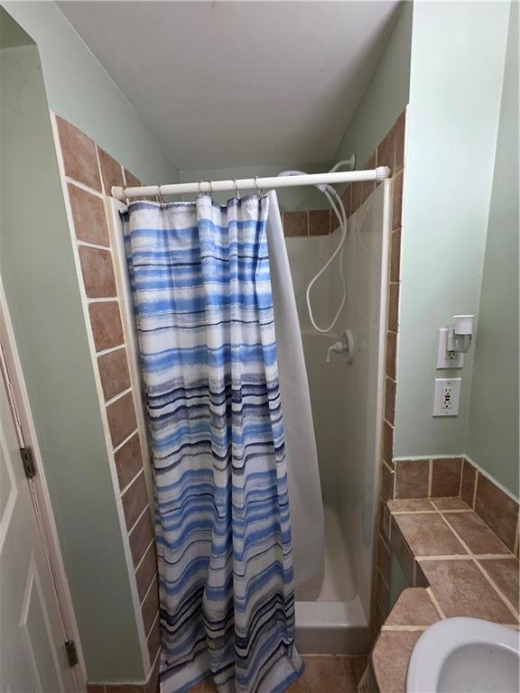 full bath with a shower stall and a sink