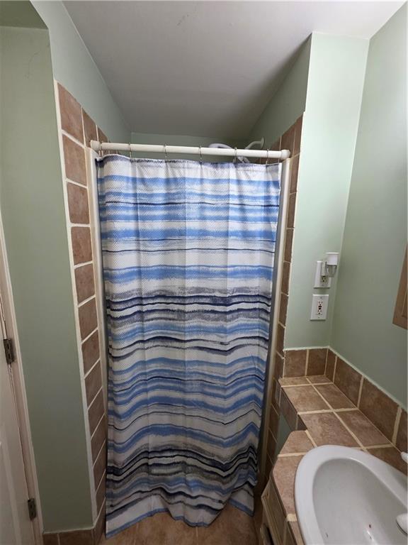 full bath with a shower with curtain and a sink