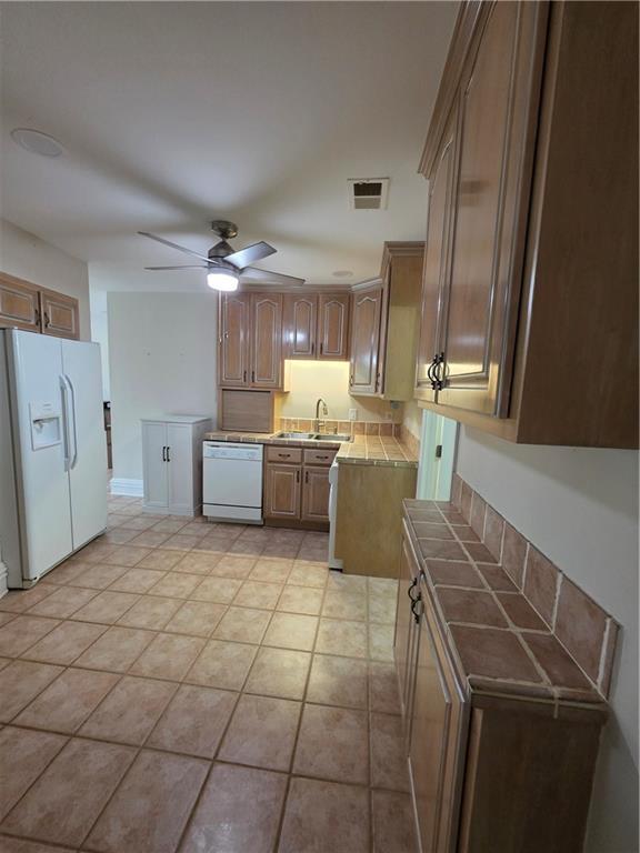 200 Valley Brook Dr, Newnan, GA 30265 - kitchen featuring white appliances, ceiling fan, a sink, tile countertops, and light tile patterned floors