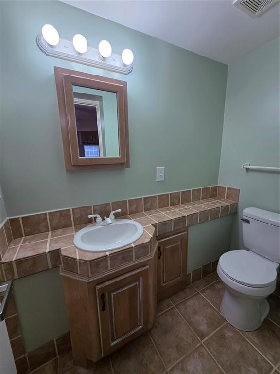 200 Valley Brook Dr, Newnan, GA 30265 - half bathroom featuring toilet, vanity, and tile patterned flooring