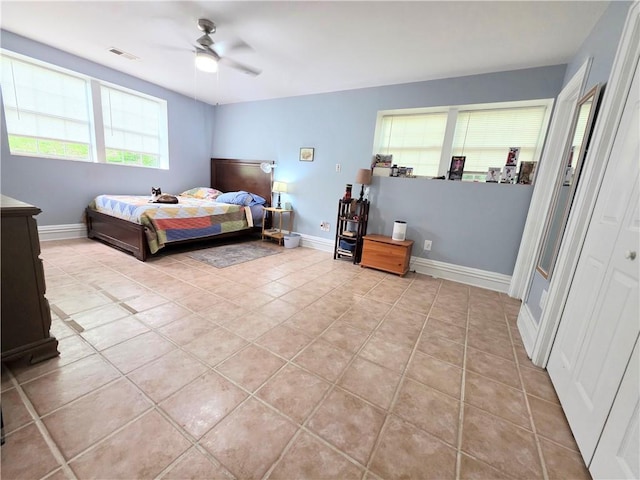 bedroom with light tile patterned floors, visible vents, ceiling fan, and baseboards