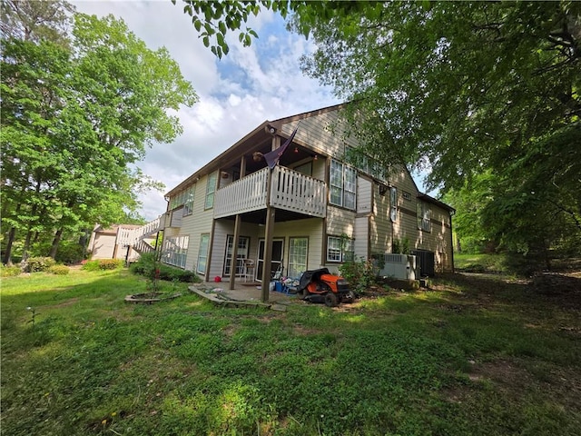 back of property with stairs, a patio area, a yard, and a wooden deck