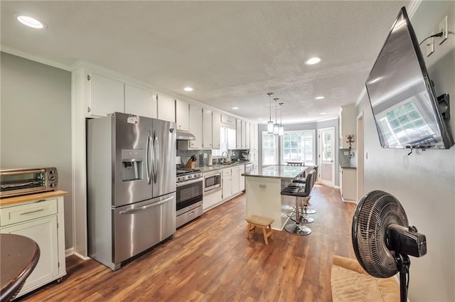 2165 Shillings Chase Dr NW, Kennesaw, GA 30152 - kitchen featuring stainless steel appliances, recessed lighting, a center island, wood finished floors, and a kitchen breakfast bar