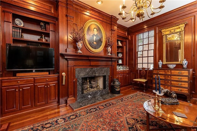 3022 Loridan Way SE, Atlanta, GA 30339 - living area featuring wood finished floors, built in features, a chandelier, a premium fireplace, and wooden walls
