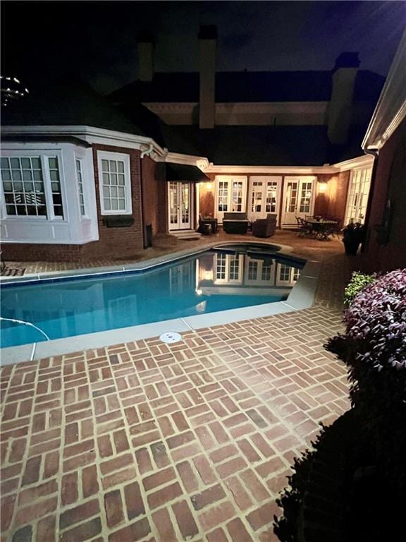 3022 Loridan Way SE, Atlanta, GA 30339 - pool at night featuring french doors, an outdoor pool, and a patio