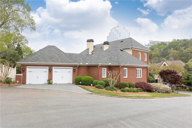 3022 Loridan Way SE, Atlanta, GA 30339 - view of front of property featuring an attached garage, brick siding, a chimney, and driveway