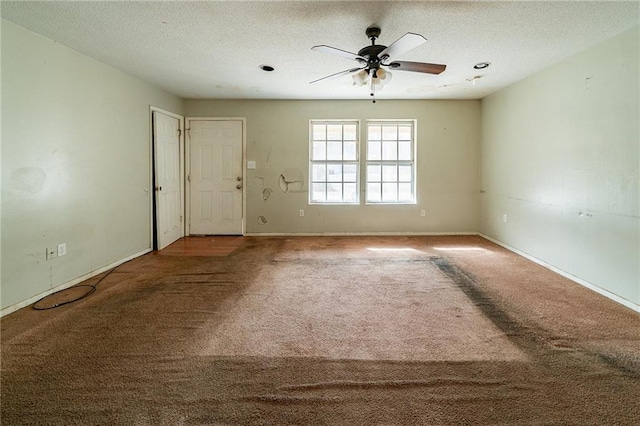 unfurnished bedroom with a textured ceiling, dark carpet, and ceiling fan