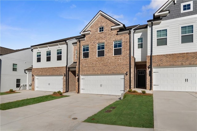 view of property with brick siding, driveway, and a garage