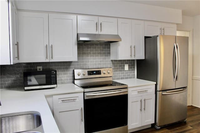 1191 Hampton Way NE, Atlanta, GA 30324 - kitchen featuring appliances with stainless steel finishes, under cabinet range hood, light countertops, white cabinetry, and decorative backsplash