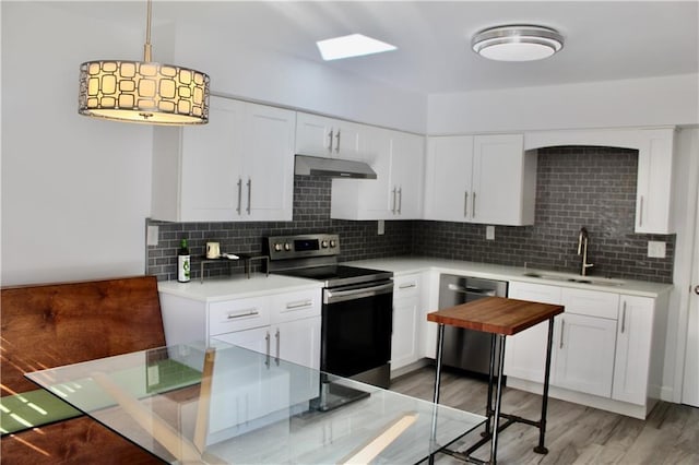 1191 Hampton Way NE, Atlanta, GA 30324 - kitchen with stainless steel appliances, under cabinet range hood, backsplash, and light countertops