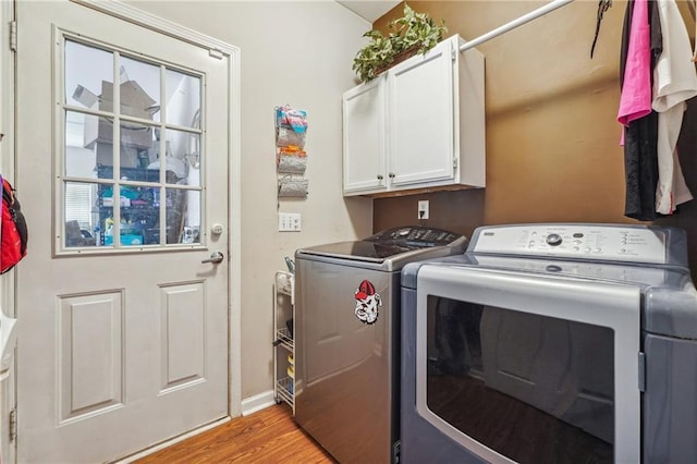 laundry area featuring light hardwood / wood-style floors, cabinets, and independent washer and dryer