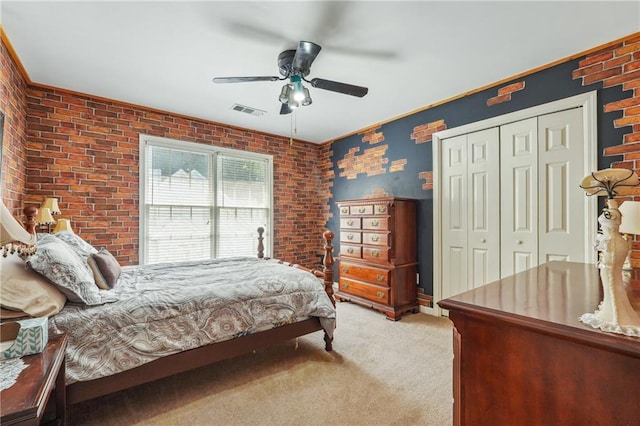 bedroom with brick wall, light carpet, a closet, ornamental molding, and ceiling fan