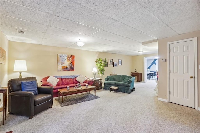 living room with a drop ceiling and carpet floors