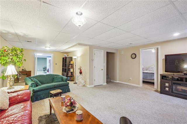 carpeted living room with a drop ceiling