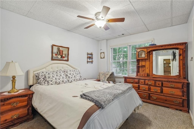 bedroom with carpet, a drop ceiling, and ceiling fan