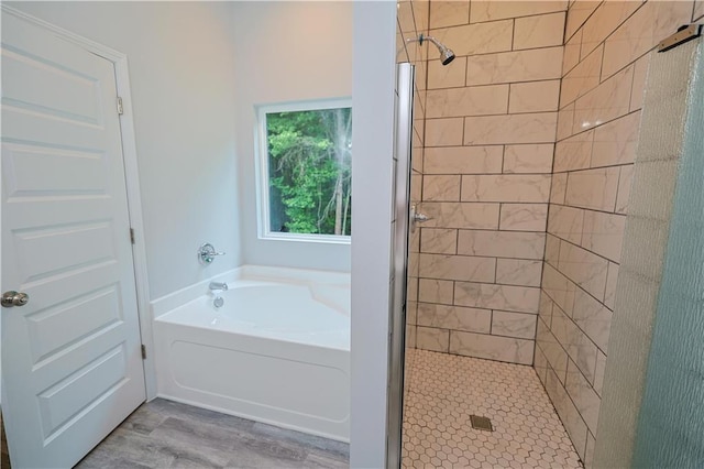 275 Green Commons Dr, Covington, GA 30016 - bathroom with a stall shower, a bath, and wood finished floors