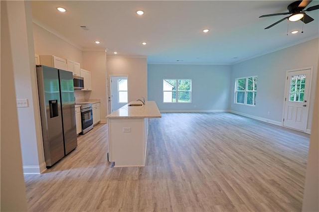 275 Green Commons Dr, Covington, GA 30016 - kitchen featuring appliances with stainless steel finishes, a sink, crown molding, white cabinetry, and light wood-type flooring