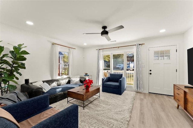 living room with ceiling fan, plenty of natural light, and light hardwood / wood-style flooring