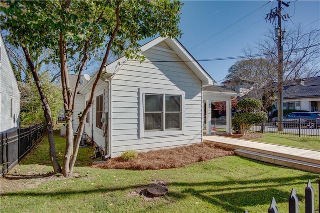 view of home's exterior with fence and a yard