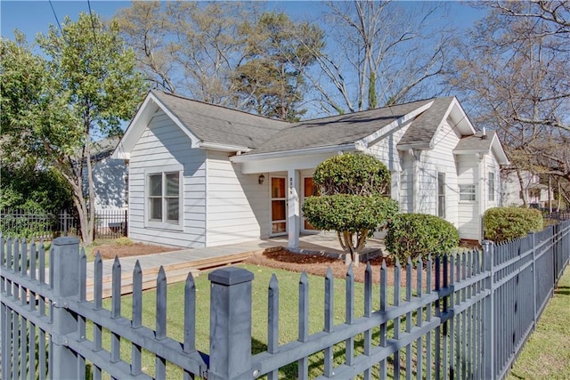 single story home featuring a front yard, a fenced front yard, and roof with shingles
