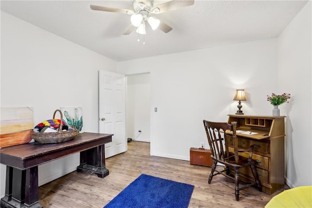 home office with hardwood / wood-style flooring and ceiling fan