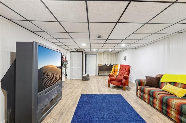 living room with wood-type flooring and a paneled ceiling