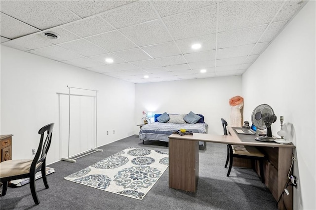 carpeted bedroom featuring a drop ceiling